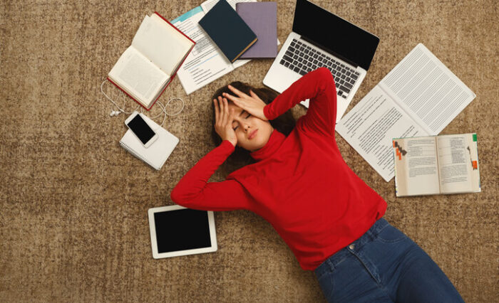 private school A private high school student is lying on the ground with books