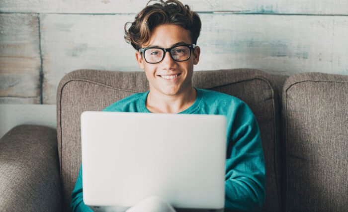 A cheerful male student taking an online course at our private school