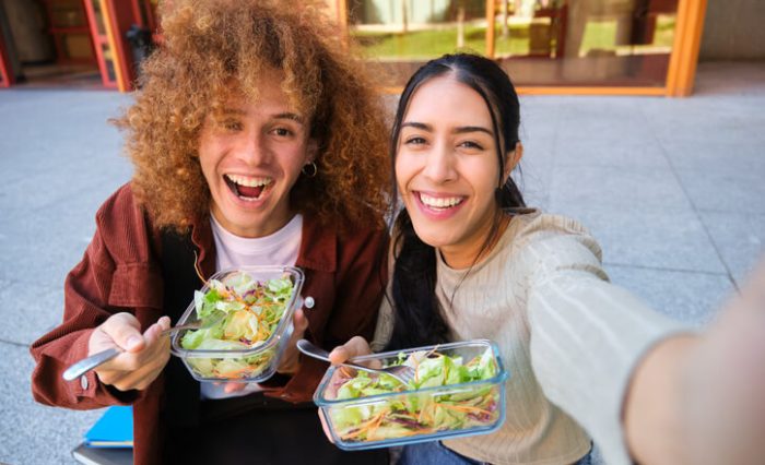 A pair of private high school students eating lunch and taking a “selfie.”